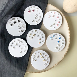 Macro shot of a mixed earring set featuring gold-toned heart, star, and moon studs
