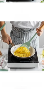 Close-up of heat-resistant mint green silicone spatula with wooden handle frying an egg