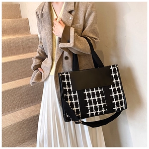 Fashionable black and white houndstooth tote bag worn with elegant business casual outfit