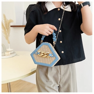 Close-up of woven shell bag with blue handles and gold chain strap detail