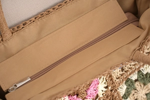 Detail of the woven tote bag featuring a metal zipper closure and fabric lining
