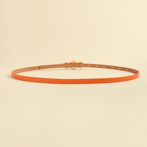 Detail of orange slim leather belt for women with golden flower metal buckle