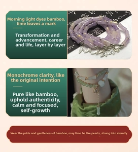 Close-up of bamboo-shaped glass beads in purple and green with gold leaf charms