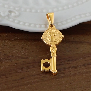 Vue macro du pendentif clé en acier inoxydable plaqué or 24 carats avec médaille Saint-Benoît