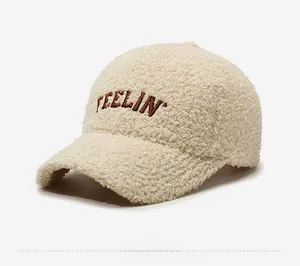 Detail view of cream teddy fleece baseball cap with brown FEELIN' embroidery