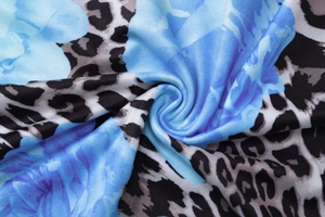 Vue macro détaillée du tissu de robe d'été avec motifs floraux bleus et imprimés léopard