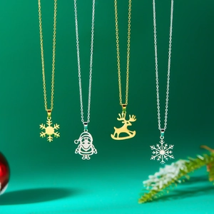 Detailed view of festive gold and silver Christmas necklaces with reindeer and snowflake charms