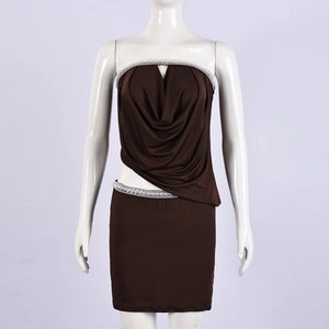 Detail van donkerbruine crop top en rok set met witte lovertjes en glanzende elastische stof