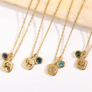 Detailed view of four 18K gold zodiac necklaces with colorful birthstone charms