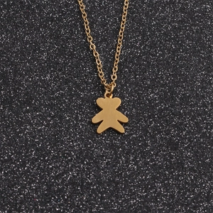 Macro detail of a golden bear pendant on a polished stainless steel chain