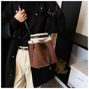 Brown suede bucket bag with white faux shearling trim and black drawstring closure