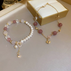 Detail of beaded strawberry crystal bracelet with pearls and a golden heart charm