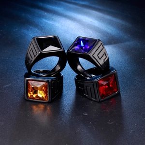Detailed macro view of four men's stainless steel rings with colorful square gemstones