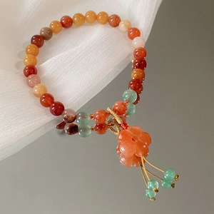 Detailansicht eines bunten Perlenarmbands mit Blumenanhänger und eleganter Quaste