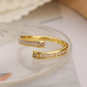 Macro detail of 18K gold plated ring featuring white enamel and sparkling zircon crystals