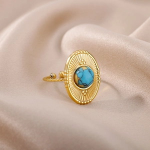 Macro detail of vintage gold adjustable ring with blue turquoise stone on silk fabric