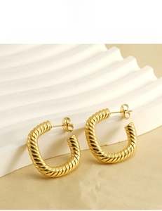 Macro detail of 18K gold plated stainless steel C-hoop earrings with textured twist design