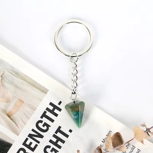 Detail showing natural green crystal stone pendant with polished metal keychain ring