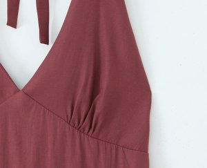 Close-up of dark red satin dress showing halter neck V-neckline and ruched waist detail