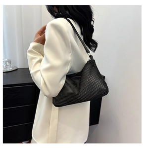 Close-up of black rhinestone shoulder bag paired with a contrast white suit
