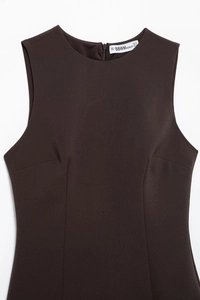Detail view of back zipper and size tag on a brown sleeveless mesh layered dress