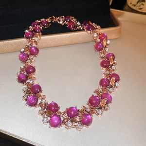 Macro shot of rose gold necklace featuring purple gemstones and sparkling crystal accents