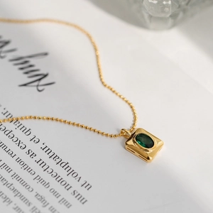 Elegant gold bead chain necklace with rectangular emerald green crystal pendant