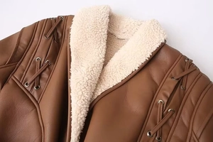 Gros plan sur la veste vintage en cuir marron avec col en peau de mouton et détails soignés