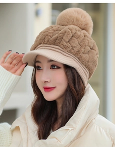 Detail of winter plush khaki baseball cap featuring thick knit brim and large faux fur pompom