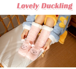 Detail of pink coral fleece slipper socks featuring a cute cartoon sheep and white trim