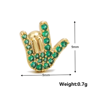 Detailed view of 9mm hand sign stud earring with green cubic zirconia in gold plating