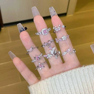 Close-up of pink zircon star and heart silver rings set worn on fingers with soft lighting