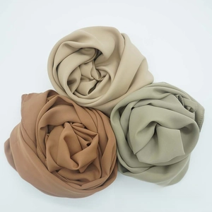 Detail of satin chiffon scarves in earth tones featuring fine rolled hem edges