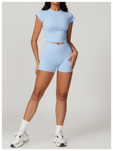 Dettaglio del set fitness azzurro con top aderente e pantaloncini sportivi a vita alta