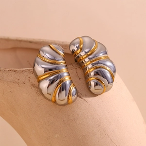 Gros plan de boucles d'oreilles cocon torsadées bicolores or 18 carats et argent sur socle