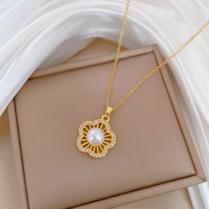 Macro shot of gold floral necklace with pearl and diamonds on silk texture