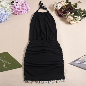 Close-up of black halter dress featuring ruched knit fabric and sequin fringe details