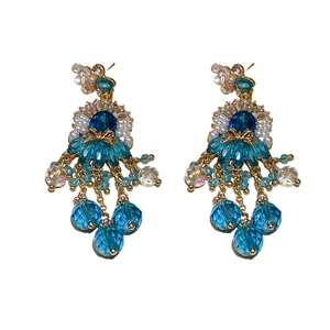 Vintage gold tassel earrings with blue faceted crystals and white floral accents