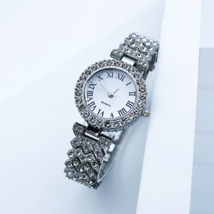 Detail shot of silver quartz watch with rhinestone-encrusted bezel and Roman numerals