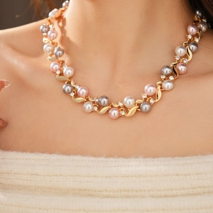 Gros plan du collier vintage doré orné de perles multicolores et de strass brillants