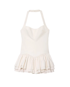 Detail of white halter neck dress featuring layered ruffle hem and fine striped texture