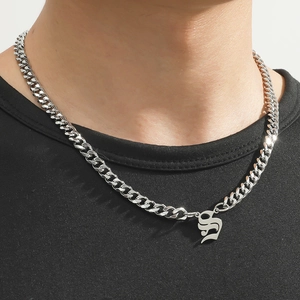 Close-up of a silver gothic letter S pendant on a polished Cuban link chain for men