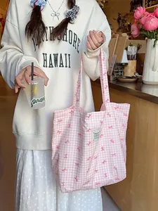 Pink checkered canvas tote bag with red bow prints and a spacious top handle design