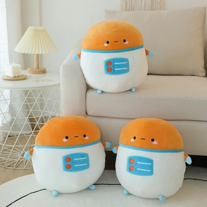 Three cute orange astronaut plush toys shown in a cozy living room setting on a sofa