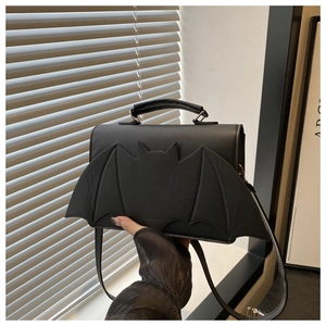 Close-up of black PU leather bat-shaped handbag with unique wing design and top handle