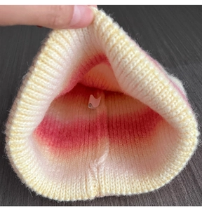 Detail of soft cream and pink tie-dye thick knit beanie showing interior texture