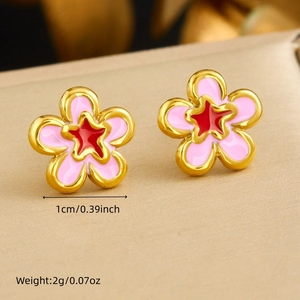 Detail shot of gold-plated pink flower earrings with red star center and size specs