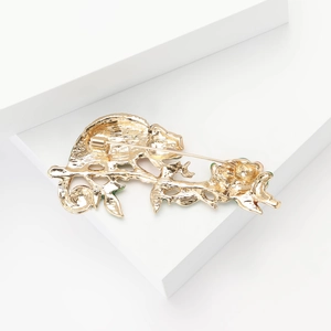Detailed view of enamel chameleon frog brooch with a gold metal pin and vibrant design