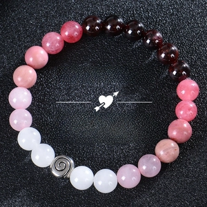 Bracelet Love Spell en quartz fraise et grenat naturel sur fond noir à texture granuleuse