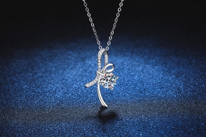 Detailed macro shot of a ribbon bow pendant with a brilliant 1-carat moissanite stone